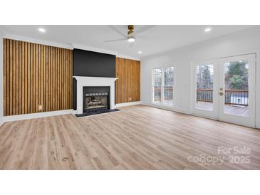 Spacious living room featuring a fireplace and wood accent wall at 13833 Jonathans Ridge Rd, Charlotte, NC 28227