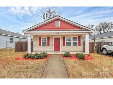 Charming single-story home with a red and beige exterior, and well-manicured landscaping at 208 Lakewood Ave, Charlotte, NC 28208