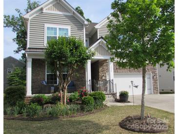 Charming two-story home featuring stone accents, a well-manicured lawn, and a welcoming front porch at 3020 Sewee Ln, Waxhaw, NC 28173