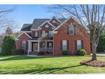 Brick home with a large front porch and landscaping at 7005 Shadow Rock Ct, Matthews, NC 28104