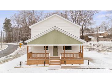 Two-story house with light-colored siding, a green accent, and a front porch at 902 N Mountain St, Cherryville, NC 28021