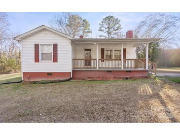 White house with red accents, covered porch, and grassy yard at 1028 White Ln, Gastonia, NC 28052
