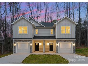 Two-story duplex home with attached garages and landscaping at 2113 Gemway Dr, Charlotte, NC 28216