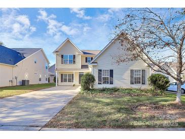 Two-story house with a beige exterior, attached garage, and landscaping at 8436 Dawson Ln, Locust, NC 28097