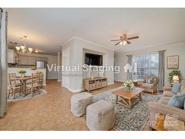 Inviting living room with tile floors, ceiling fan, large windows, and comfortable seating at 5110 Osage Cir, Charlotte, NC 28269