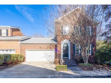 Brick front exterior of charming townhome with attached garage and inviting front steps at 9451 Bonnie Briar Cir, Charlotte, NC 28277