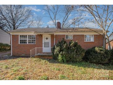 Brick ranch house with a yard and mature shrubs at 437 Brevard St, Statesville, NC 28677