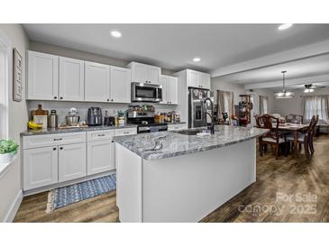 Modern kitchen with white cabinets, granite island, and stainless steel appliances at 1278 Burrell Rd, Clover, SC 29710
