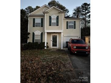 Two-story house with tan siding, dark shutters, and a red Jeep parked in the driveway at 2868 Oasis Ln, Charlotte, NC 28214