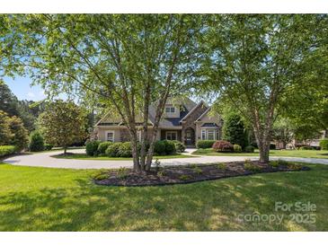 Charming home featuring mature trees, manicured landscaping, and circular driveway at 4150 Summit Ridge Ln, Denver, NC 28037