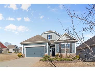 Attractive craftsman style home with gray siding, two-car garage, and landscaping at 5007 Grand Champion Ct, Iron Station, NC 28080