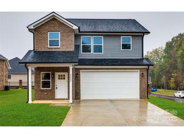 Two-story brick home with a white garage door and a well-manicured lawn at 5050 Ashley Pl, Bessemer City, NC 28016