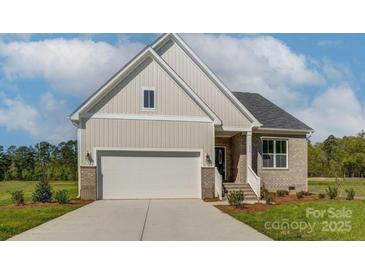 Beige house with white garage door and landscaping at 804 Pierce Ave, Mount Holly, NC 28120