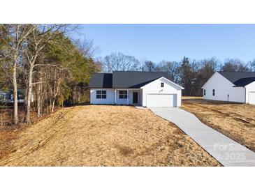 White house with gray roof, two-car garage, and driveway at 4109 Pebblebrook Sw Cir, Concord, NC 28027