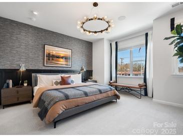 This main bedroom features designer touches, like an exposed wall, modern lighting, and large windows at 5628 Kingspan Dr, Charlotte, NC 28217