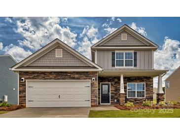 Two-story home with stone and shingle accents, two-car garage, and landscaped yard at 3686 Charles Nw St, Conover, NC 28613