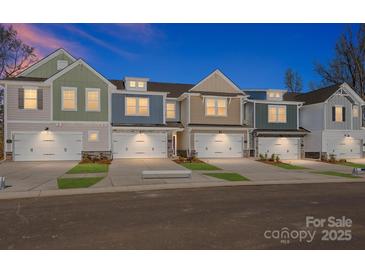 Charming new townhomes feature attached garages and stone accents for modern curb appeal in a walkable neighborhood at 113 Quartz Hill Way, Waxhaw, NC 28173