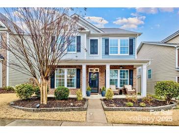 Two-story home with brick and siding, welcoming porch, and landscaped yard at 14015 Helen Benson Blvd, Davidson, NC 28036