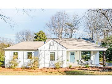 Charming single-story home with light blue door, covered porch, and beautiful landscaping at 711 Concord Rd, Davidson, NC 28036