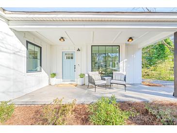 Inviting front porch with seating area and a light blue front door at 711 Concord Rd, Davidson, NC 28036