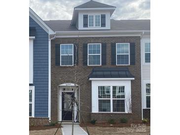 Two-story brick townhome with dark shutters and a metal roof at 12841 Canton Side Ave, Charlotte, NC 28273