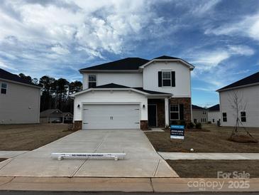 Two-story home featuring white siding, a two-car garage, and a well-manicured front yard with 'for sale' signage at 1515 Harper Landing Blvd, Stanley, NC 28164