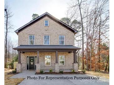 Two-story brick home with a front porch and landscaping at 604 Impala Dr, Albemarle, NC 28001