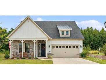 Charming home with stone and siding exterior, a two-car garage, and a well-manicured lawn at 212 Portrait Way, Indian Trail, NC 28079