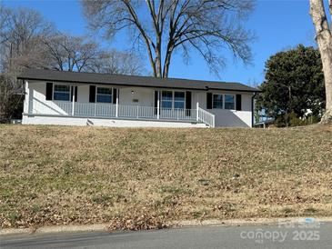 Newly renovated ranch home with a white brick exterior and covered porch at 3225 Cricketeer Dr, Charlotte, NC 28216