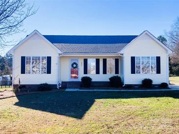 Ranch style home with yellow siding, black shutters, and a well-maintained lawn at 623 Faith St, Oakboro, NC 28129