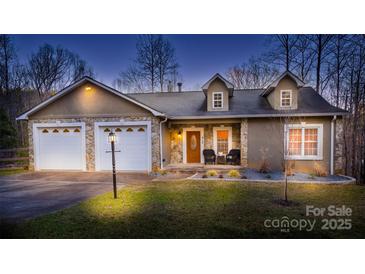 Two-story house with two-car garage, stone accents, and landscaped yard at 412 Wildlife Rd, Troutman, NC 28166