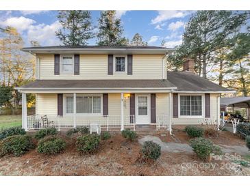 Two-story house with yellow siding, front porch, and landscaping at 9 Post Oak Pl, Salisbury, NC 28147