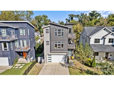 Modern gray home with a two-car garage, balconies, and a well-manicured lawn, perfect for urban living at 416 Wesley Heights Way, Charlotte, NC 28208