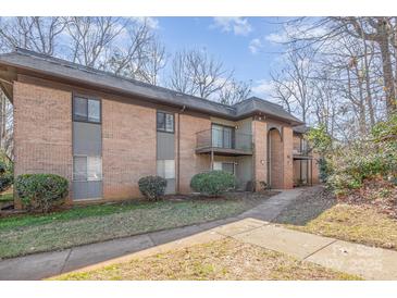 Brick exterior with a sidewalk leading to units and trees surrounding the property at 133 Orchard Trace Ln # 7, Charlotte, NC 28213