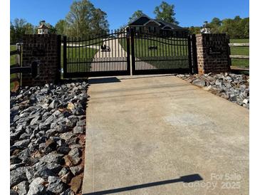 Grand gated entrance to Hando Farm with brick pillars and ironwork, leading to a beautiful property at 1370 Null Rd, Lincolnton, NC 28092
