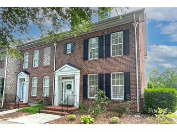 Charming brick townhome featuring a welcoming entrance, black shutters and well-maintained landscaping at 156 Singleton Rd, Mooresville, NC 28117