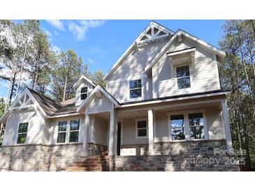 Beautiful two-story home featuring stone accents, dormer windows, and a covered front porch with large support columns at 5053 Townsend Rd, Lancaster, SC 29720