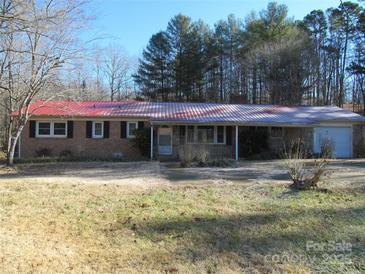 Brick ranch home with red metal roof, detached garage, and large yard at 744 N Little Egypt Rd, Denver, NC 28037