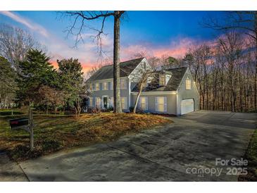 Two-story house with gray siding, white shutters, and a long driveway at 2702 Oxborough Dr, Matthews, NC 28105