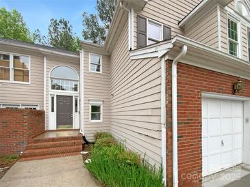 Charming home featuring a brick facade, arched entryway, and attached two car garage at 4818 Whistling Oak Ct, Charlotte, NC 28269