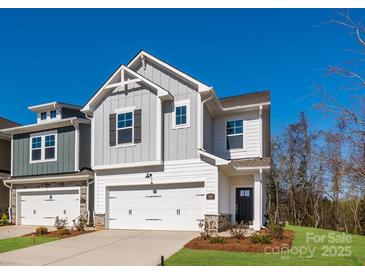 Charming two-story home with a two-car garage and well-manicured lawn against a vibrant blue sky at 119 Quartz Hill Way, Waxhaw, NC 28173