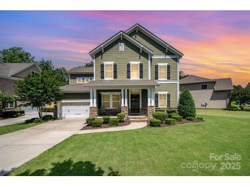 Two-story house with green siding, stone accents, and a landscaped lawn at 15049 Easywater Ln, Charlotte, NC 28278