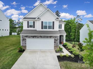 Charming two-story home boasts a stone facade and landscaped front yard at 18022 Stark Way, Charlotte, NC 28278