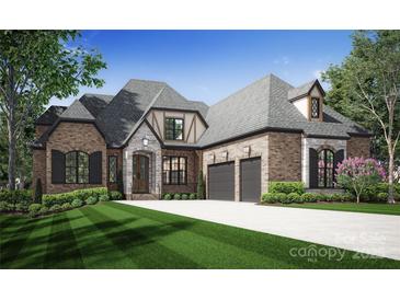 Brick home with a 2-car garage and manicured lawn at 613 Deodar Cedar Dr, Weddington, NC 28104