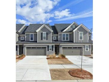 Gray townhome with two-car garage and landscaped front yard at 23010 Clarabelle Dr # 70, Charlotte, NC 28273