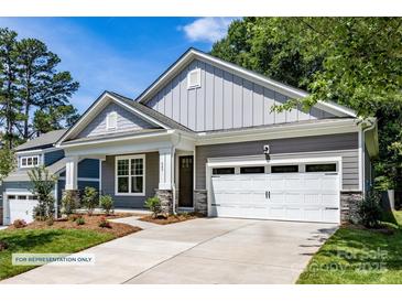 Craftsman style home with gray siding, white garage door, and landscaping at 600 Banter Ln # 27, Cramerton, NC 28032