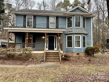 Two-story house featuring a wraparound porch and a spacious yard at 701 Victorian Ln, Monroe, NC 28112