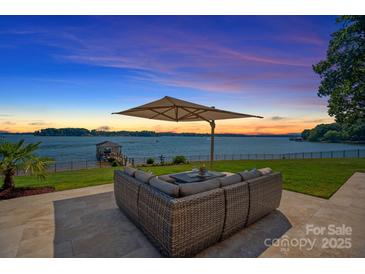 Relaxing patio furniture with lake view and sunset at 132 Rollingwood Ln, Mooresville, NC 28117