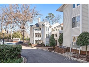 Exterior view of a charming light beige townhouse with landscaping and parking at 2715 Selwyn Ave # 47, Charlotte, NC 28209