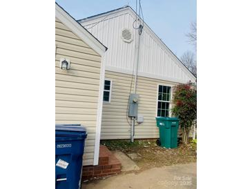 A view of the side of the home, highlighting the siding and backyard access at 640 Mckee St, Albemarle, NC 28001